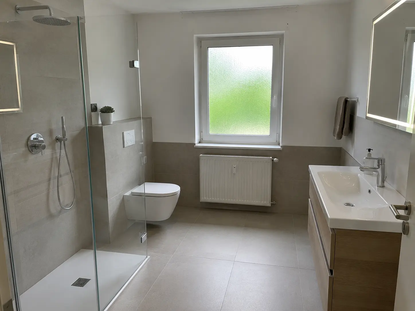 Modernes Badezimmer mit Regendusche und Holzwaschtisch