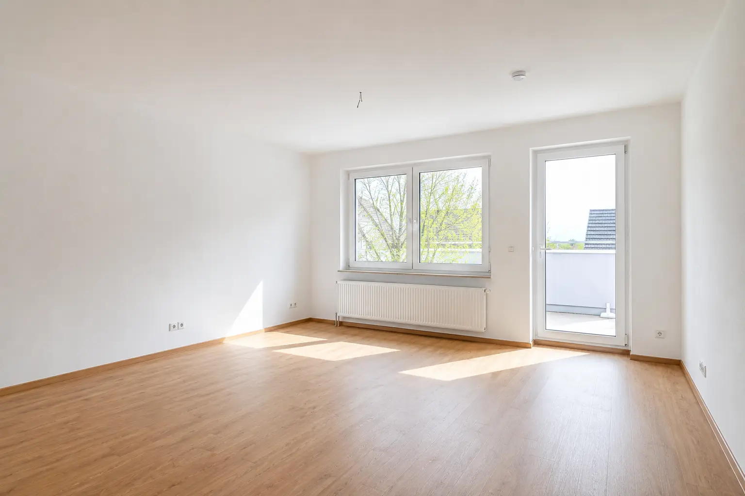 Helles Wohnzimmer mit Balkonzugang einer Kaufimmobilie in Saarbrücken