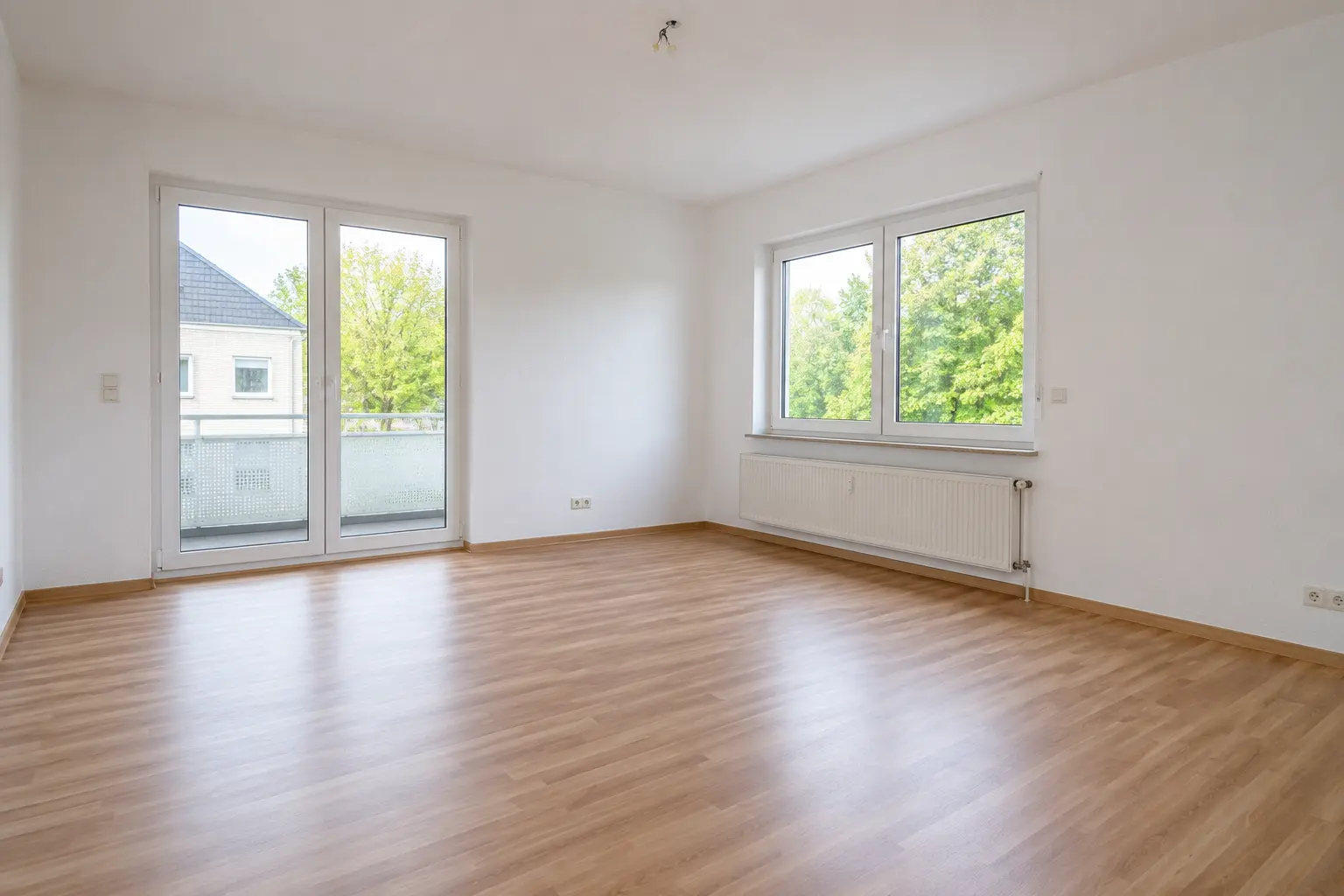 Helles Zimmer mit Balkon und Fenster einer Kaufimmobilie in Saarbrücken